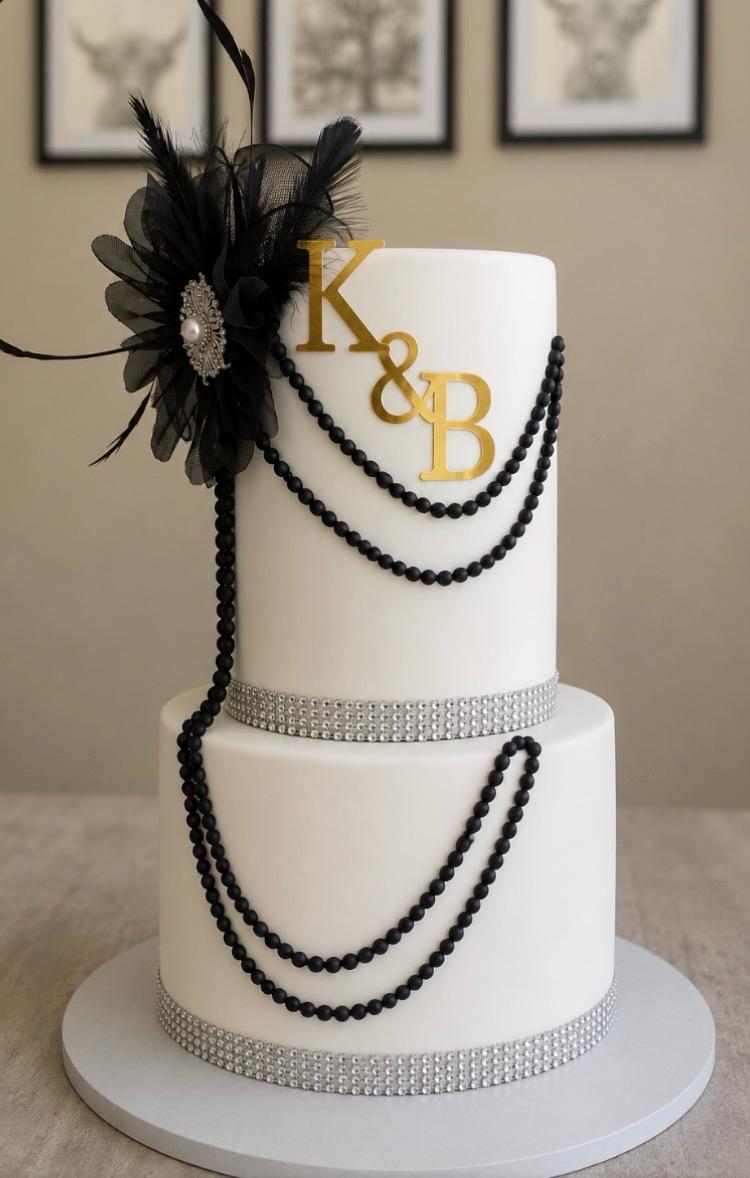 Two-tier vintage cake with black beads and gold initials